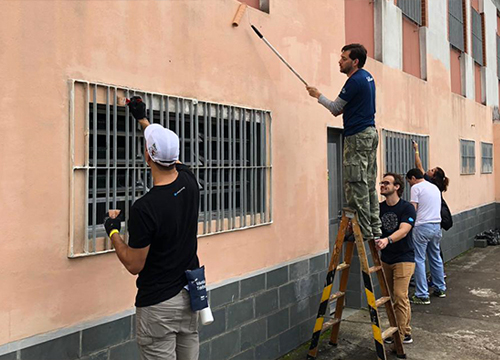 Foto time da Salesforce pintando a fachada da Ong Cidade dos Velhinhos Santa Luiza de Marillac