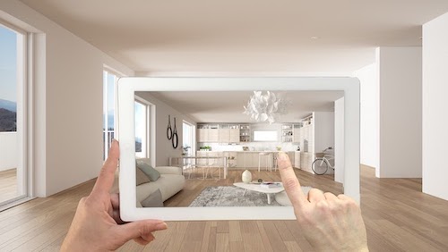 Photo of a woman designing her living room layout using augmented reality.