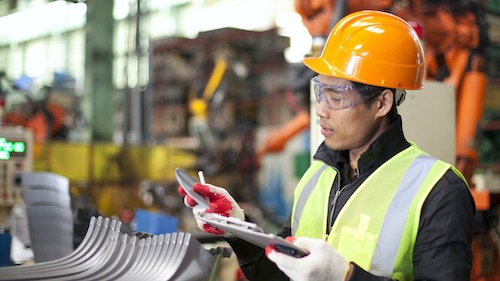 Man in hardhat works on tablet device
