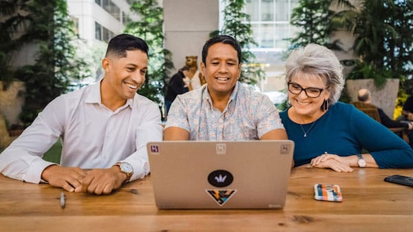 Photo of colleagues around a laptop