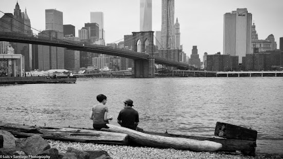 A couple chats beside NYC's East River