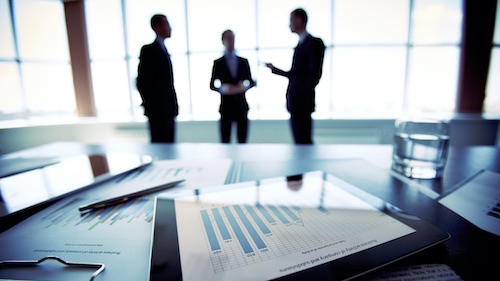 Three business people with a desk in the foreground