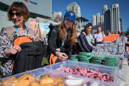 Volunteers stuff backpacks for local schools