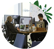 Two people working on their laptops and computer monitors at Salesforce