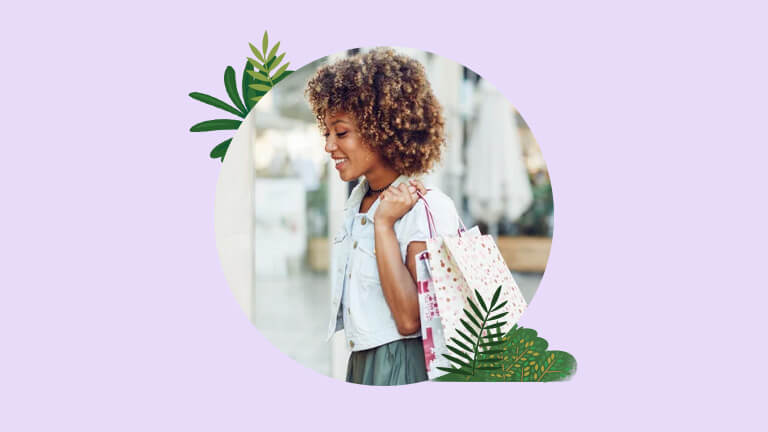 A woman walks in a shopping mall with a shopping bag over her shoulder