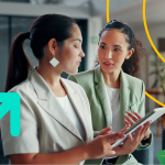 Two female sales people discussing sales enablement holding tablets