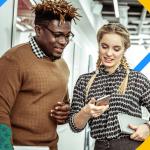 Two people talking about sales engagement while looking at a cell phone in an office setting