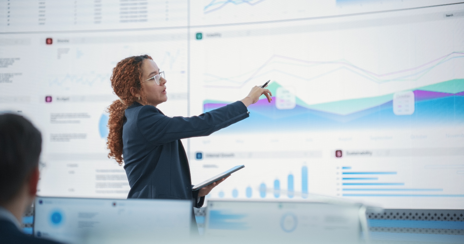 A woman pointing at charts on a whiteboard