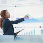 A woman pointing at charts on a whiteboard