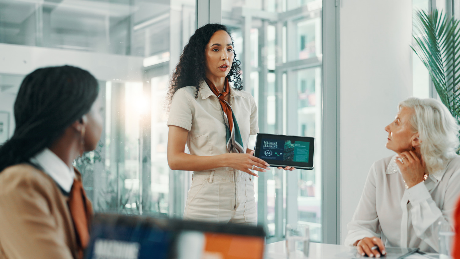 Women in a boardroom discussing AI revolution, workforce automation, and machine learning strategies.