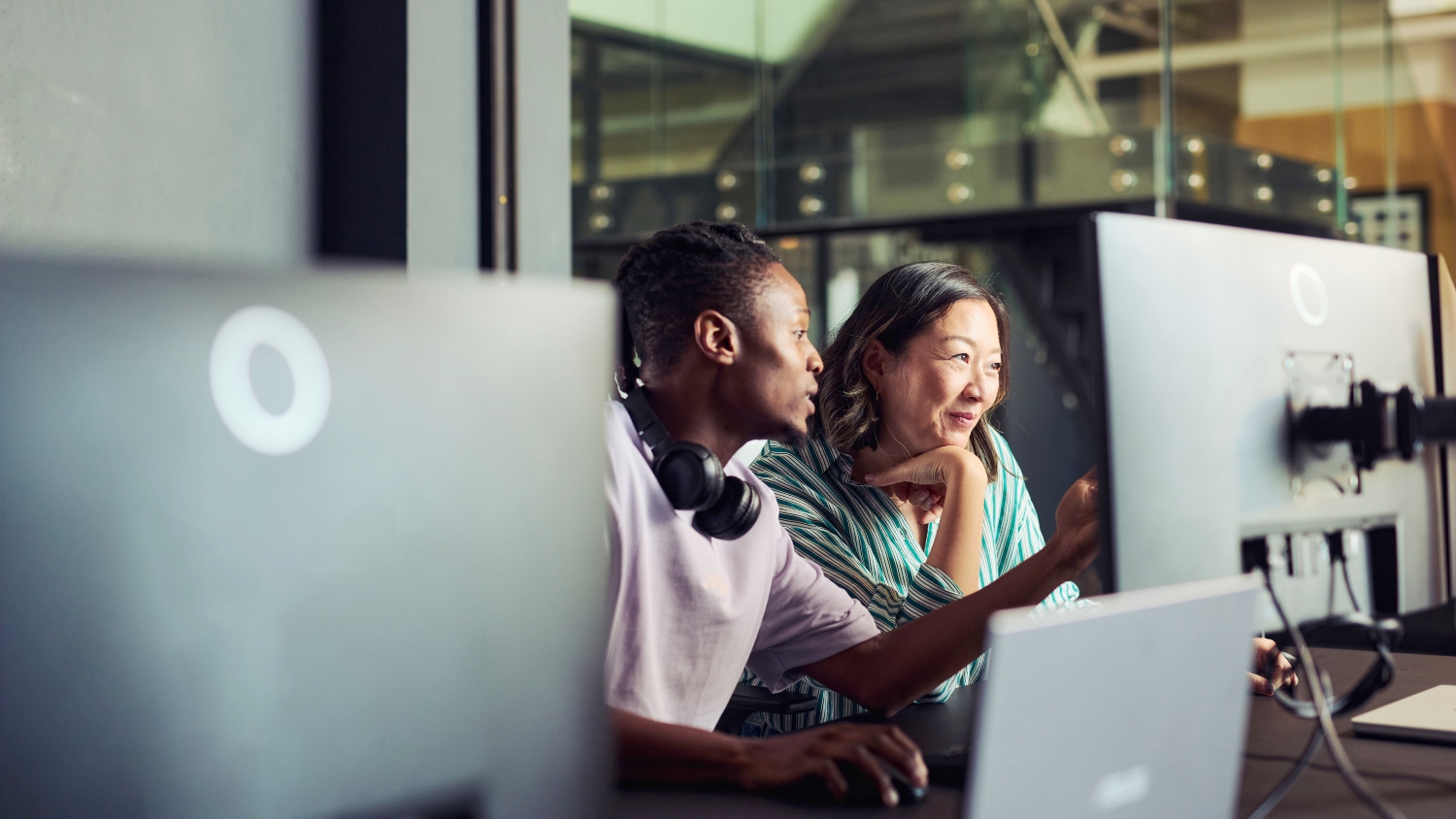 Two people at work looking at a computer screen.