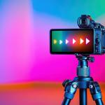 A camera on a tripod with a colorful background.