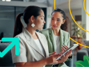 Two female sales people discussing sales enablement holding tablets