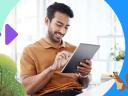 Sales person smiling and looking at a laptop while thinking about sales performance management