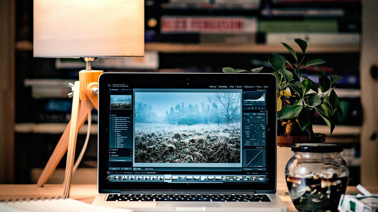 A cozy workspace featuring a laptop displaying a photo editing application.