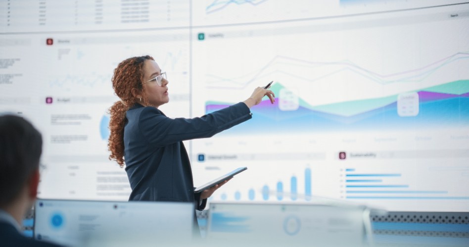 A woman pointing at charts on a whiteboard