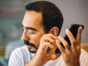 A blind man uses assistive technology on his phone to access content.