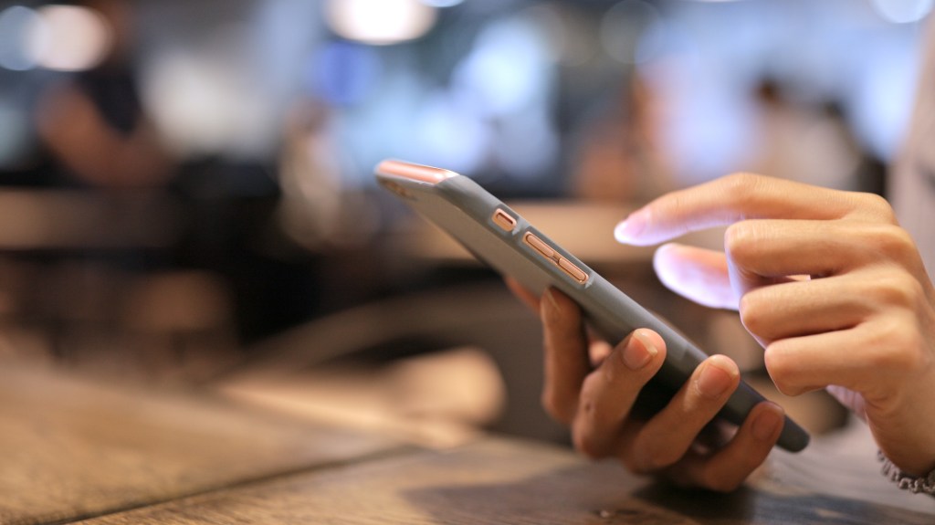 Hands tapping mobile phone