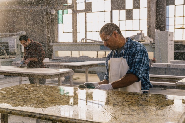 factory workers manufacturing a marble table
