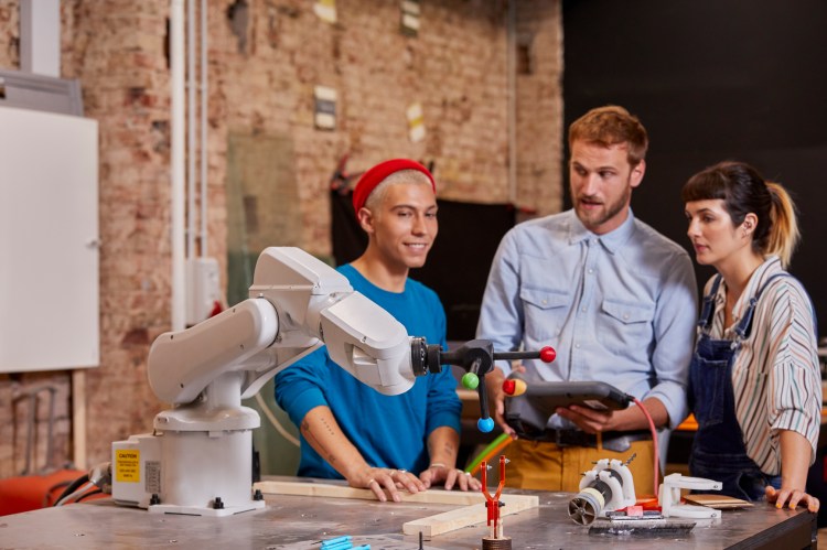 People working with robotic arm