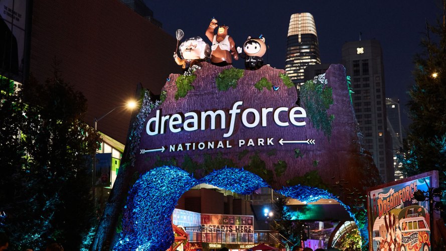 night time shot of welcome arch at dreamforce with Salesforce Tower in background