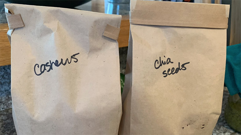 two paper bags that contain cashews and chia seeds, an eco-friendly way to storage food
