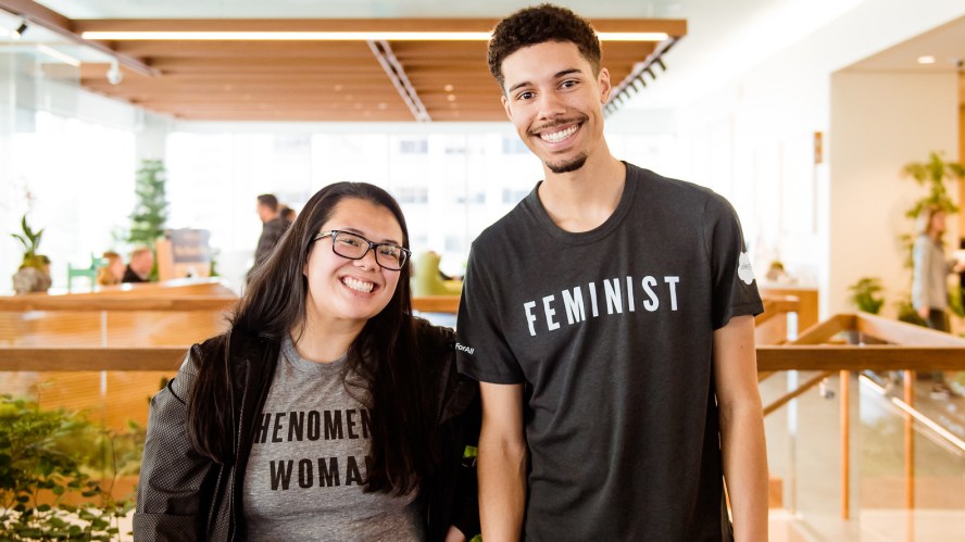 A person wearing a phenomenal woman tee and another person wearing a feminist tee