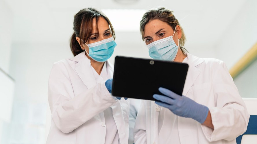 Two female doctors looking at information on an ipad