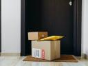 a stack of delivered packages sitting on a front stoop: order management trends