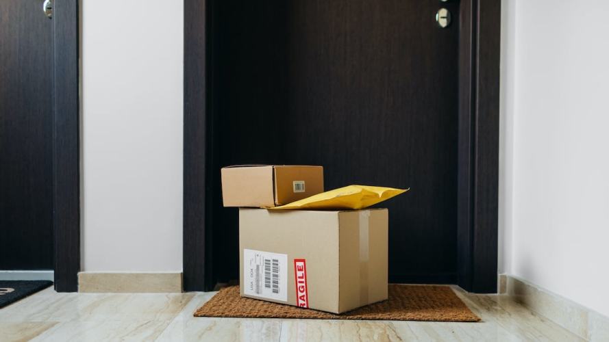 a stack of delivered packages sitting on a front stoop: order management trends