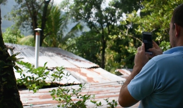 A nonprofit employee takes a photo of cookstove installation to get feedback in near-real-time, using Mogli SMS