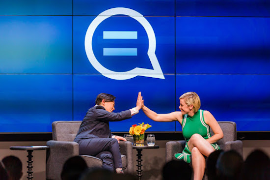 Photo of Michelle Meow and Lauren Morelli high-fiving on stage after sharing a candid moment