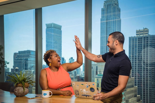 Two employees hi-five each other at Salesforce