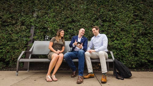 Photograph of three people on a park bench