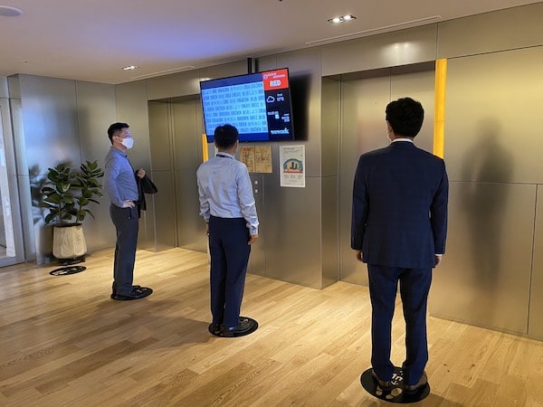 Employees stand on physically distanced floor decals