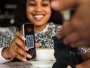 Woman showing QR code on her mobile phone to a merchant.