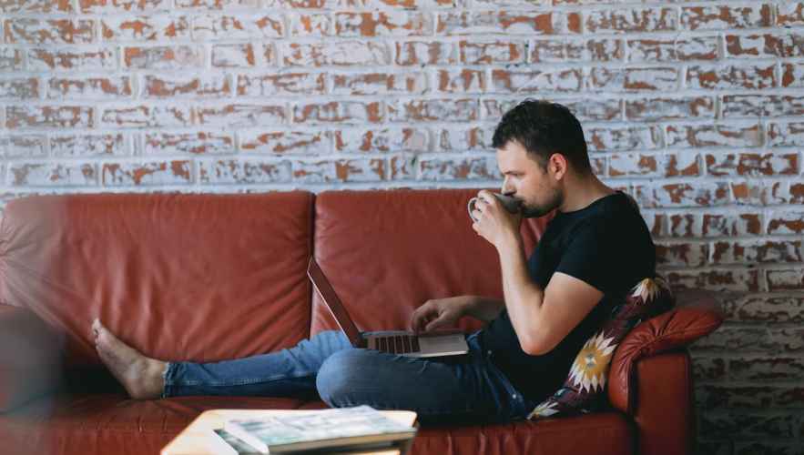 Man relaxing on couch upskilling with online learning