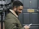 smiling person with earbuds and a phone