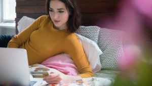 Woman lying in bed and shopping online