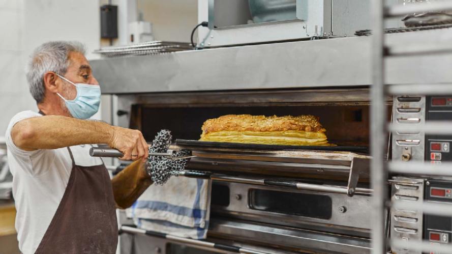 man baking in front of industrial oven small business