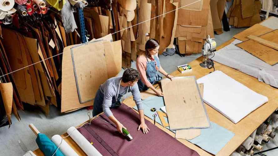 man and woman working on fabric cutting room floor