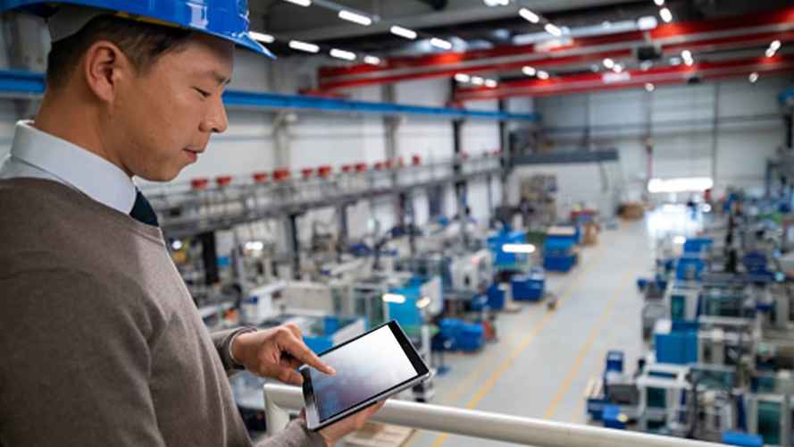 Worker using his tablet on the manufacturing floor