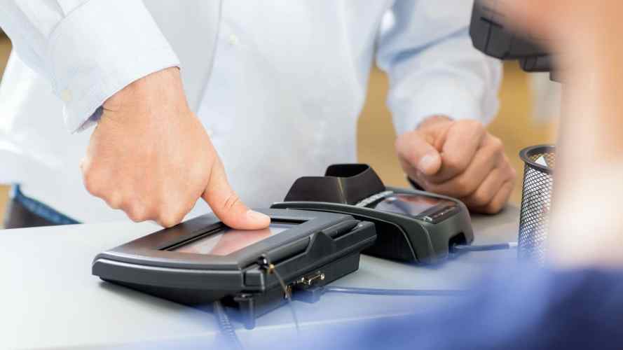 Man uses biometric thumbprint scanner at a pharmacy