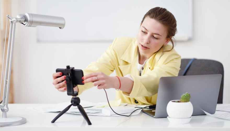 Webinar host setting up her camera on her desk