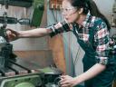 side view woman working on industrial manufacturing equipment / manufacturing partners