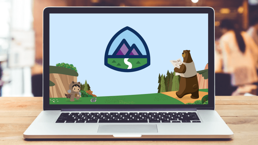 Laptop showing the Trailhead homepage and logo in a blurred office setting