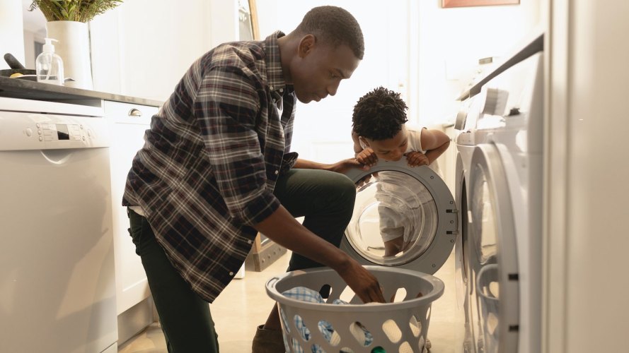 Father and son remove laundry from dryer