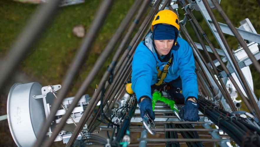 Worker climbing a telecommunications tower