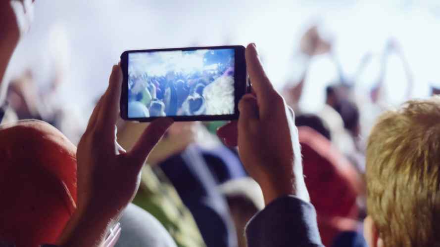Using a mobile phone at a concert is an example of 5G monetization strategies at work