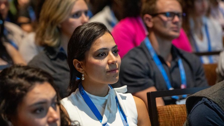 A woman listening from the audience, perhaps at a previous Salesforce Connections event.
